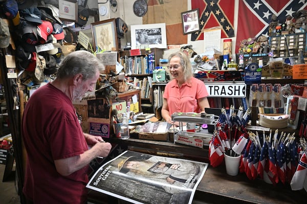 June 16, 2022 Kennesaw - Marjorie Lyon (right), the new owner, helps a longtime customer Mickey Magruder at Wildman's Civil War Surplus in Kennesaw on Thursday, June 16, 2022. The store first opened in downtown Kennesaw in 1971. When the owner, Dent Myers died in January, Marjorie Lyon vowed to keep the shop open. Councilman James “Doc” Eaton resigned from Kennesaw City Council Tuesday over the reopening of Wildman’s Civil War shop. (Hyosub Shin / Hyosub.Shin@ajc.com)