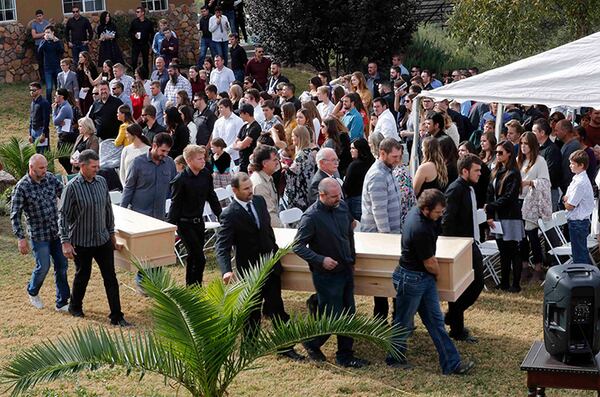 Men carry the remains of the victims before they are buried at a family cemetery in La Mora, Sonora state, Mexico, on Thursday.