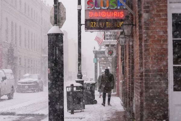 A man walks down Bourbon Street during a very rare snowstorm in New Orleans, Tuesday, Jan. 21, 2025. (AP Photo/Gerald Herbert)