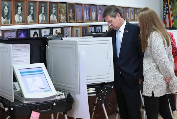 Brian Kemp, shown with his daughter Amy Porter while he was campaigning in 2018 to become Georgia's governor, casts his vote at the Winterville Train Depot in Athens-Clarke County. Curtis Compton/ccompton@ajc.com