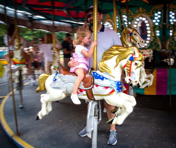 People enjoy the carousel in the amusement park rides area during the Lemonade Days Festival in Dunwoody on Sunday, August 22, 2021. STEVE SCHAEFER FOR THE ATLANTA JOURNAL-CONSTITUTION