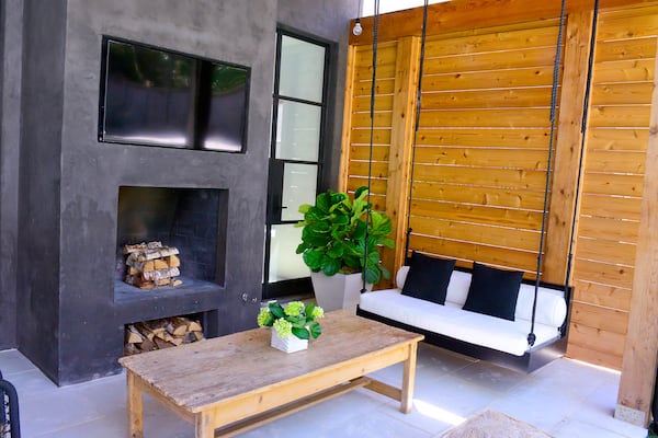 In the sitting area, a custom swing beckons the three daughters to do their homework on the back porch. A fireplace with a television above also provides a warm and inviting place to entertain guests.