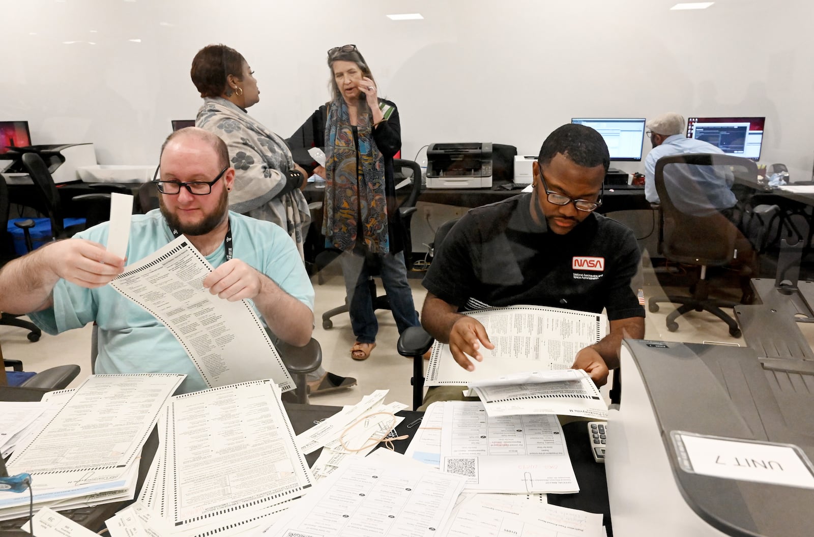 Gwinnett County poll workers prepare to tabulate mail-in-ballots.