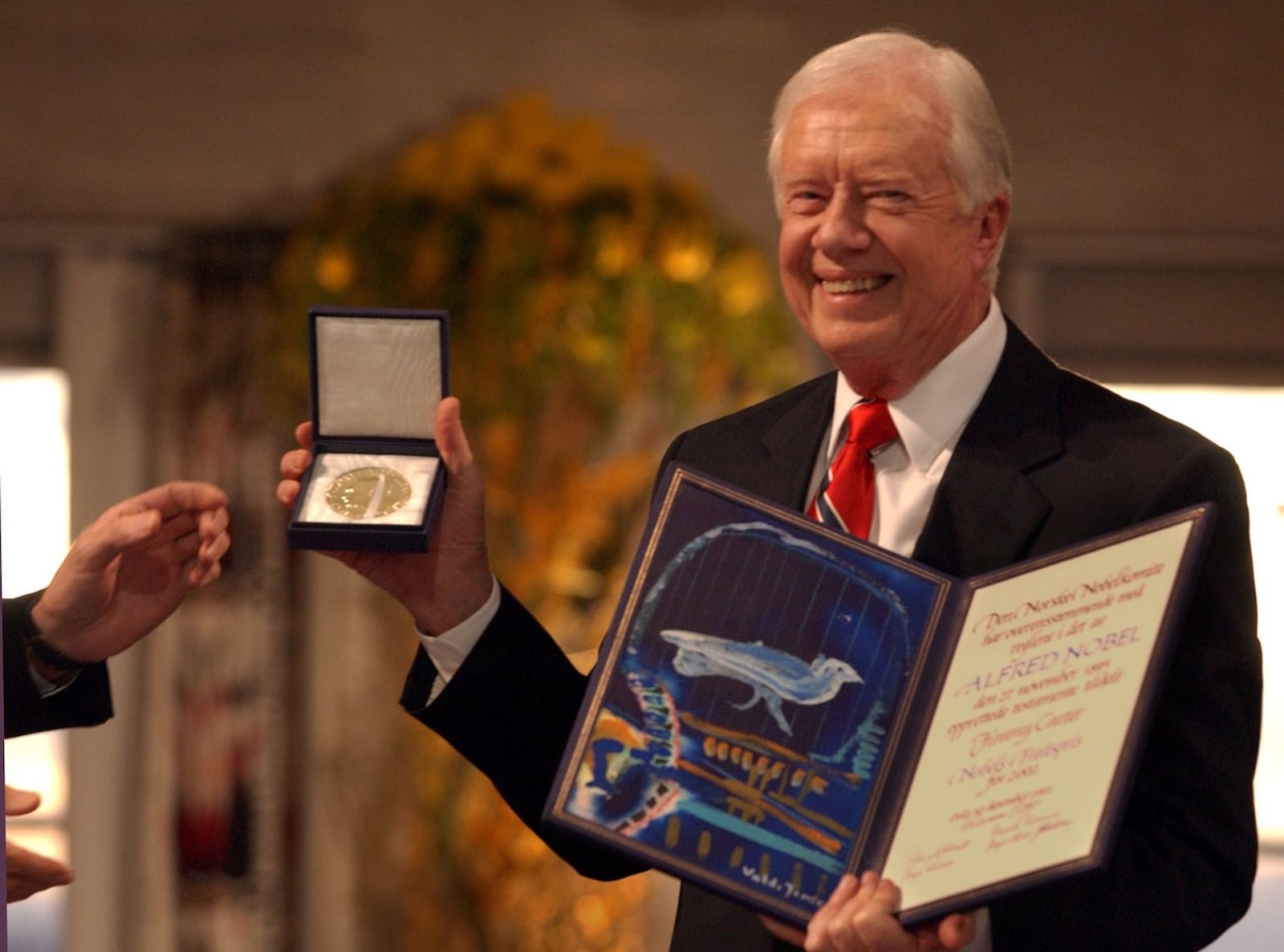 Nobel Peace Prize winner Jimmy Carter shows the Nobel medal and diploma to the audience in the Oslo on December 10, 2002. (Joey Ivansco, AJC)