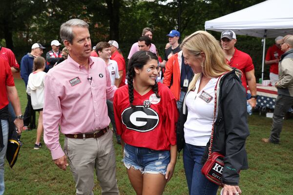 Governor Brian Kemp and his wife Marty, right, talk with UGA senior Stephanie Reyes, center, after she got a photograph with the Kemps at Herty Field before the Georgia football team hosted Samford, Saturday, September 10, 2022, in Athens. (Jason Getz / Jason.Getz@ajc.com)