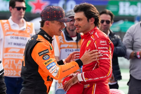 the Formula One Mexico Grand Prix auto race winner Ferrari driver Carlos Sainz of Spain, right, talks with the second place McLaren driver Lando Norris of Britain at the Hermanos Rodriguez racetrack in Mexico City, Sunday, Oct. 27, 2024. (AP Photo/Moises Castillo)