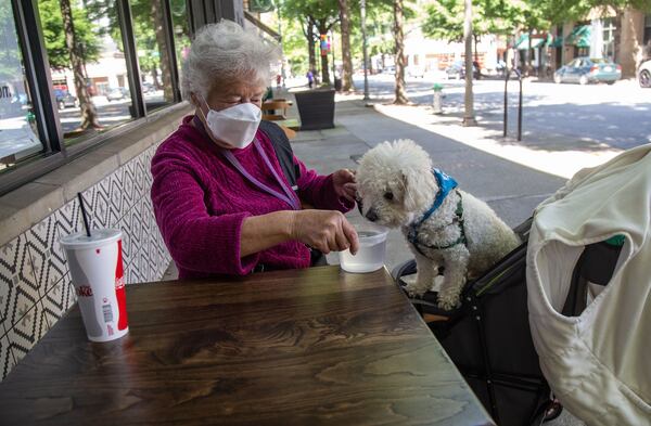 Carol Murff waits for her breakfast outside the Folk Art Restaurant with her dog Darcy Saturday in Decatur. STEVE SCHAEFER / SPECIAL TO THE AJC