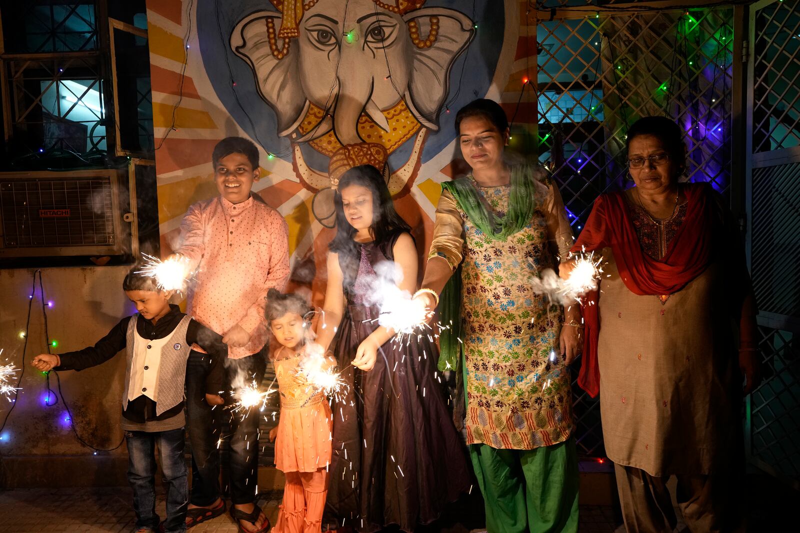 FILE- An Indian family lights firecrackers to celebrate Diwali, the Hindu festival of lights, in Prayagraj, in the northern state of Uttar Pradesh, India, Oct. 24, 2022. (AP Photo/Rajesh Kumar Singh, File)