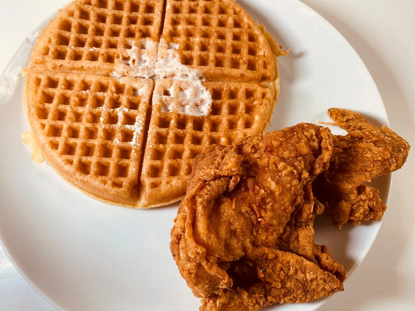 Johnny’s Chicken and Waffles signature dish can be ordered with a choice of protein, a plain or red velvet waffle and several sauces.