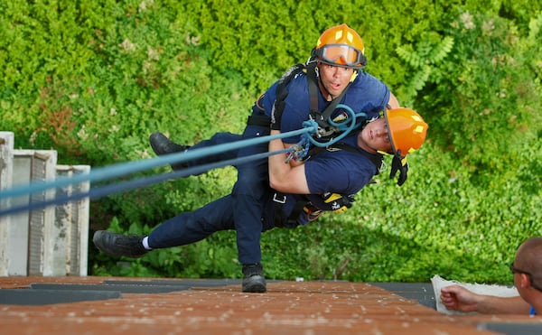 A photo of Frank Martinez (left) and another firefighter during rope training in 2010. JOHN SPINK / JSPINK@AJC.COM