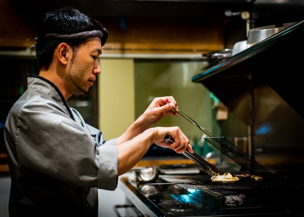 Chef Takashi Otsuka is seen at the robata grill in his restaurant Chirori, now closed temporarily. CONTRIBUTED BY HENRI HOLLIS