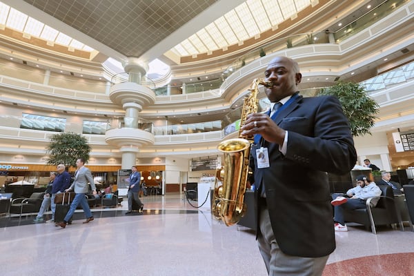 Dwan Bosman performs on sax in the domestic terminal atrium. Hartsfield-Jackson hires live musicians to calm and entertain travelers in the terminal and on the concourses. BOB ANDRES /BANDRES@AJC.COM