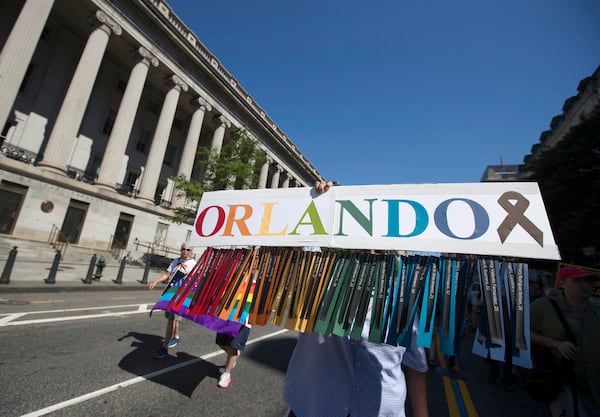 Gil Mendez, of San Francisco, holds a sign to honor the victims of the shooting at the Pulse Nightclub in Orlando, Fla., as he marches during the Equality March for Unity and Pride in Washington, Sunday, June 11, 2017. (AP Photo/Carolyn Kaster)