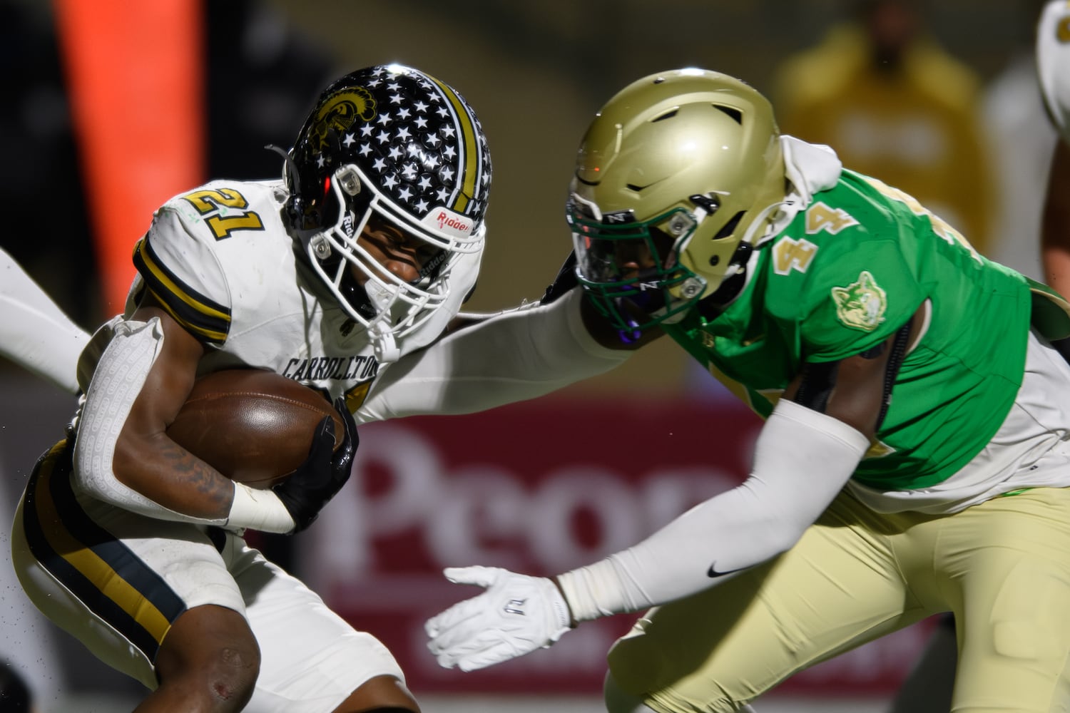 Carrollton’s Kimauri Farmer (left) readies for a collision against Buford in a 6A semifinal in Buford on Friday night. (Jamie Spaar for the Atlanta Journal Constitution)