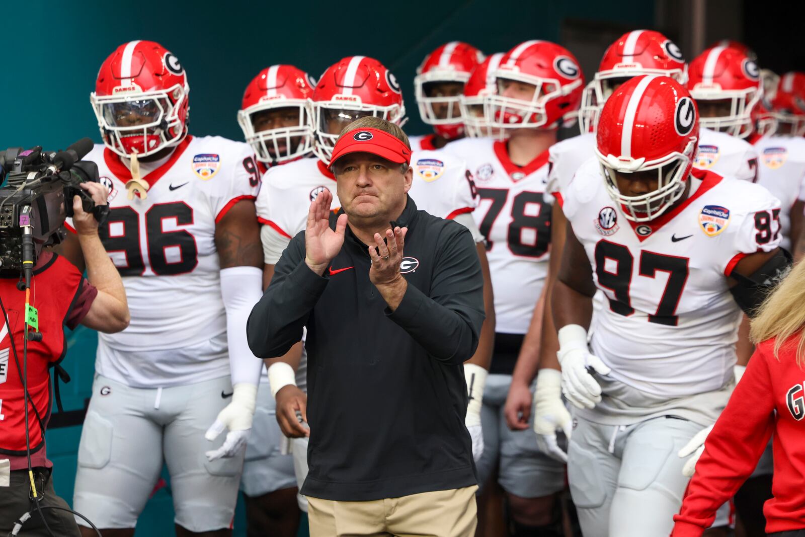 Georgia head coach Kirby Smart leads Georgia defensive lineman Zion Logue (96), defensive lineman Warren Brinson (97), and others onto the field for warm-ups before their game against Florida State in the Orange Bowl at Hard Rock Stadium, Saturday, Dec. 30, 2023, in Miami Gardens, Florida. (Jason Getz/Jason.Getz@ajc.com)