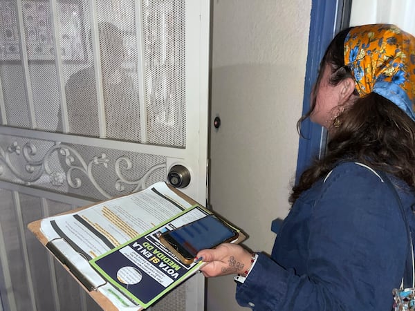 FILE - Tania Ortega, 27, speaks with a Santa Ana, Calif. resident on Wednesday, Oct. 23, 2024, about Measure DD, which would allow noncitizens to vote in local elections. (AP Photo/Jaimie Ding, File)