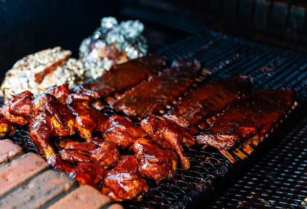 Chicken and ribs cooking on the titular brick pit at Old Brick Pit BBQ.