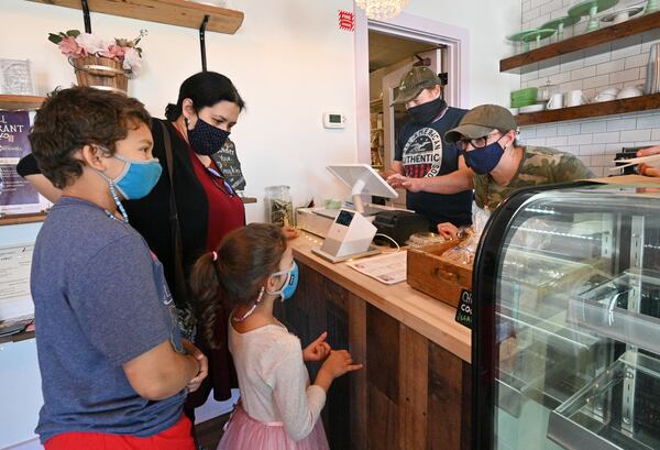 Sebastian Gracey and Cristy Kisner (right) help customers Natalia Meneses-Toler with her children Ignacio (left), 9, and Antonin, 6, at Cristy's Kitchen in Roswell. Gracey and Cristy were featured on the Humans of New York account on Instagram where creator Brandon Stanton helped raise more than $1.2 million for the restaurant.  (Hyosub Shin / Hyosub.Shin@ajc.com)