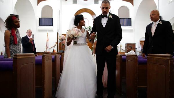 Two-time Olympic jumper Jamie Nieto, right, who was paralyzed from neck down 15 months ago after a spinal cord injury, walks down the aisle with his bride Shevon Stoddart after their wedding ceremony Saturday, July 22, 2017, in El Cajon, Calif. Step by halting step, Nieto made good on his vow to walk his new wife down the aisle of the church and out the door to a waiting limousine. It was roughly 130 steps, with a stop about halfway down the aisle for a kiss to appease the photographers. No cane, no walker, just his right arm holding onto his wife's left arm. (AP Photo/Jae C. Hong)