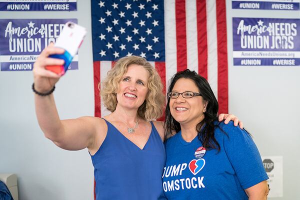 Juli Briskman, left, who was fired from her job after giving President Donald Trump's motorcade the middle finger while cycling in 2017, won a seat on the Loudoun County Board of Supervisors on Tuesday night.