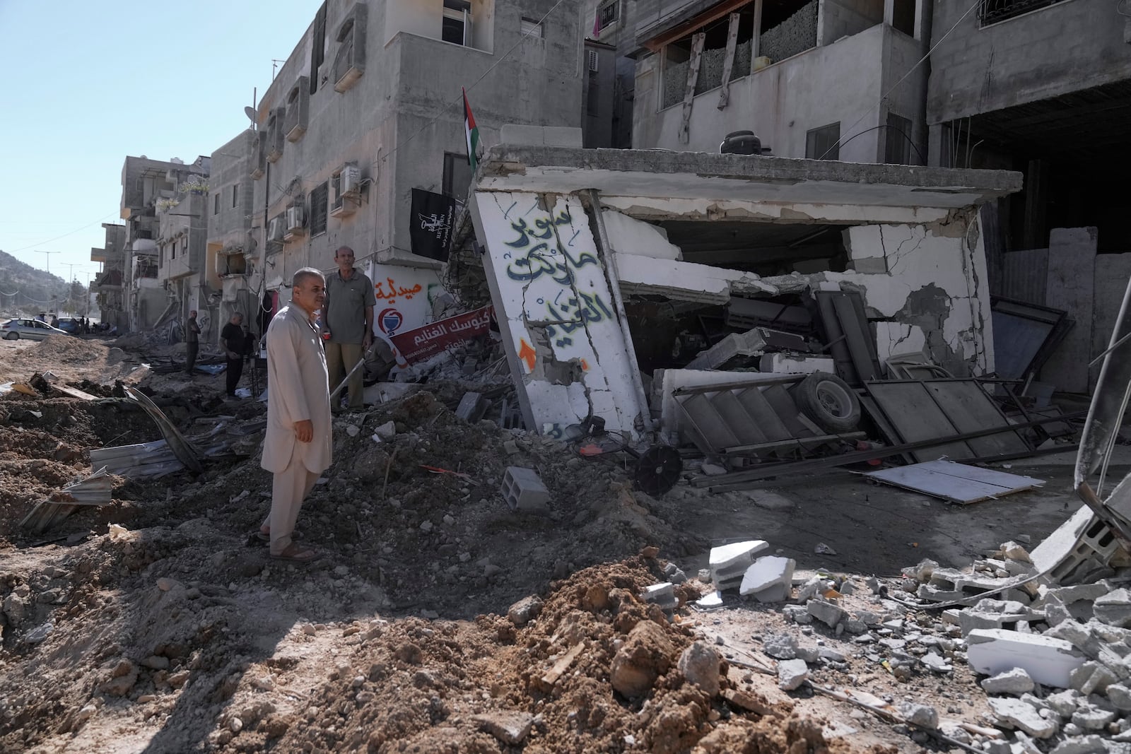 People inspect the destruction following an Israeli forces raid in Tulkarem, West Bank, on Wednesday, Sept. 11, 2024. (AP Photo/Majdi Mohammed)