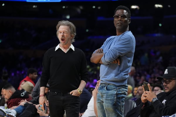 Comedians Chris Rock, right, and David Spade stand near their seats during a break in the first half of an NBA basketball game between the Los Angeles Lakers and the Memphis Grizzlies, Wednesday, Nov. 13, 2024, in Los Angeles. (AP Photo/Marcio Jose Sanchez)