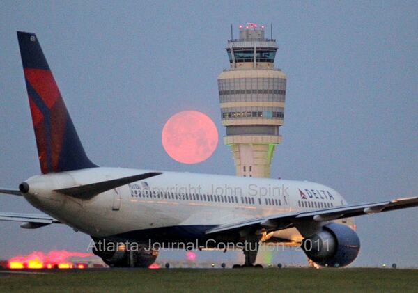 110418 Atlanta: A pink April moon loomed over the Hartsfield-Jackson International Airport control tower Monday, April, 18, 2011. New scheduling rules for air traffic controllers aimed at reducing fatigue on the job will be rolled out Monday, beginning in Atlanta. Randy Babbitt, head of the Federal Aviation Administration, will visit control tower staff at Hartsfield-Jackson International Airport, and FAA control facilities in Fayette and Henry counties, to kick off a nationwide tour of briefings that will unveil the new guidelines for overnight staffing. Extending hours between shifts and restricting night-time schedule swapping are among the changes. The move comes as a fifth air traffic controller in a month was reported asleep on duty: this time early Saturday morning, during a midnight shift at a regional radar facility in Miami that monitors high-altitude flights. The Miami controller didn't miss any flight calls because there were more controllers on duty, but has been suspended, FAA officials said. â€œWe expect controllers to come to work rested and ready to work and take personal responsibility for safety in the control towers; we have zero tolerance for sleeping on the job,â€ Secretary of Transportation Ray LaHood said Sunday in a statement. â€œSafety is our top priority and we will continue to make whatever changes are necessary.â€ Already, FAA administrator Randy Babbitt and LaHood had ordered additional air traffic controllers assigned to overnight shifts at 27 airports that operated around the clock with only one controller working late. This came after a controller fell asleep early Wednesday morning at the Ren0-Tahoe International Airport and missed guiding in a medical flight. The new scheduling rules have already been put in place and will be fully in effect by the end of the week. John Spink jspink@ajc.com