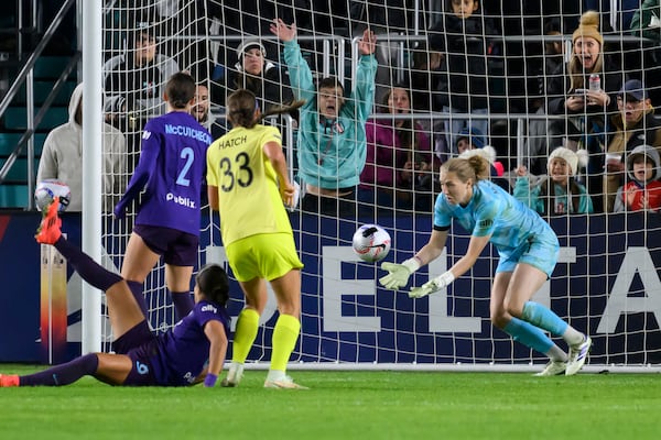 Orlando Pride goalkeeper Anna Moorhouse, right, blocks a shot on goal by Washington Spirit during the second half of the NWSL championship soccer game at CPKC Stadium, Saturday, Nov. 23, 2024, in Kansas City, Mo. (AP Photo/Reed Hoffmann)