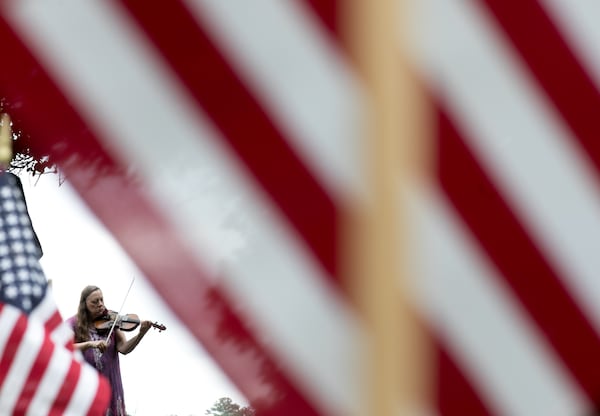 A woman plays patriotic songs at Marietta National Cemetery ahead of Memorial Day observances, Saturday, May 26, 2018, in Marietta, Ga. BRANDEN CAMP/SPECIAL