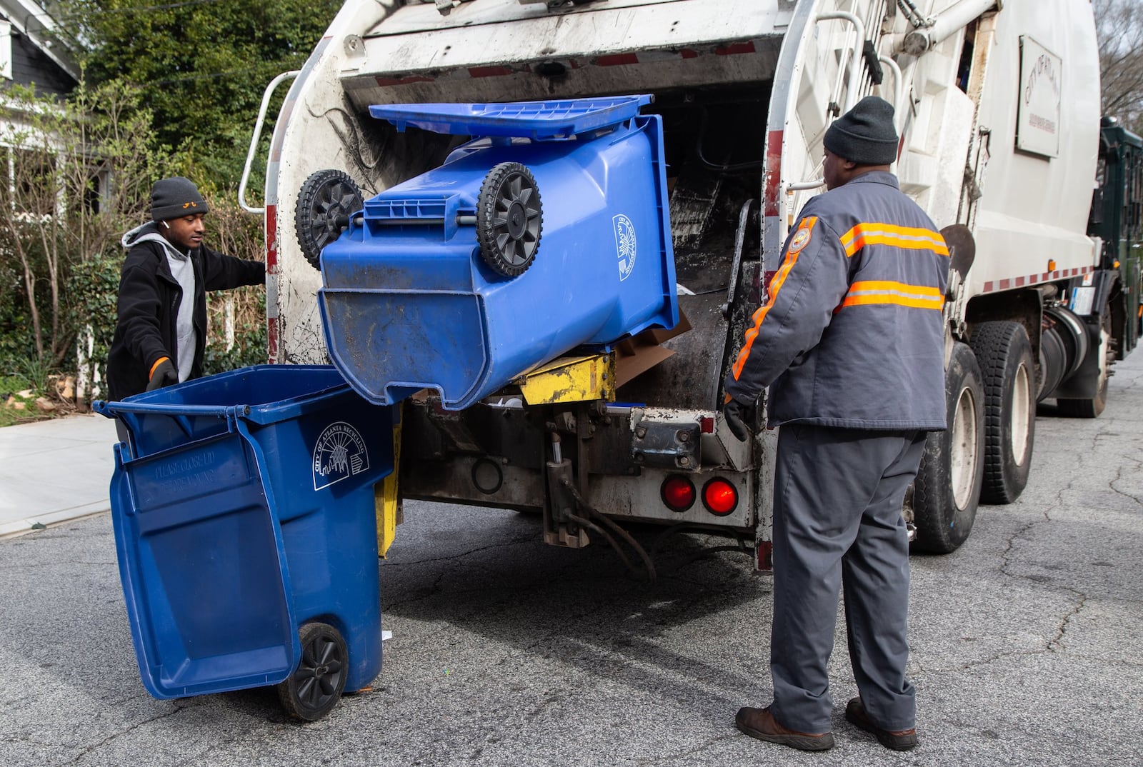 Sean Johnson (left) and Mike Reed pick up recycling bins for the city of Atlanta in the Ormewood Park area on March 7, 2019. The city of Atlanta has a 26 percent contamination rate in its single-stream curbside recycling program, according to Pratt Recycling, which was contracted by the city in 2016 to handle recycling services. CONTRIBUTED BY PHIL SKINNER