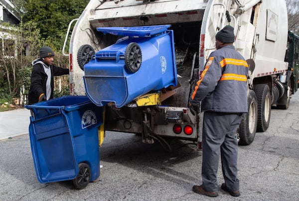 Sean Johnson (left) and Mike Reed pick up recycling bins for the city of Atlanta in the Ormewood Park area on March 7, 2019. The city of Atlanta has a 26 percent contamination rate in its single-stream curbside recycling program, according to Pratt Recycling, which was contracted by the city in 2016 to handle recycling services. CONTRIBUTED BY PHIL SKINNER