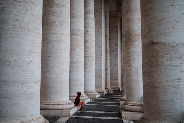 A woman sits in St. Peter's Square at The Vatican, Monday, Feb. 24, 2025. (AP Photo/Bernat Armangue)