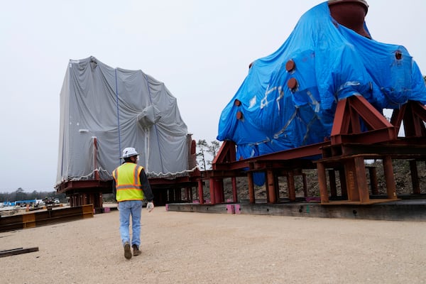 John Watts, senior project engineer, walks between a high pressure/intermediate turbine, right, and low pressure turbine, left, at Entergy's Orange County Advanced Power Station, a 1,215-megawatt facility under construction, Monday, Feb. 24, 2025, in Orange, Texas. (AP Photo/David J. Phillip)