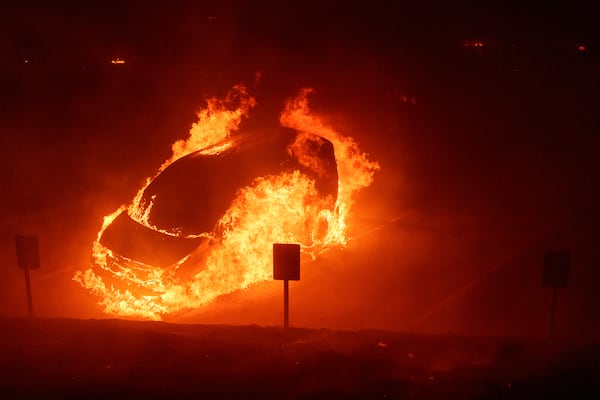 A vehicle burns during the Franklin Fire on the campus of Pepperdine University in Malibu, Calif., Tuesday, Dec. 10, 2024. (AP Photo/Eric Thayer)