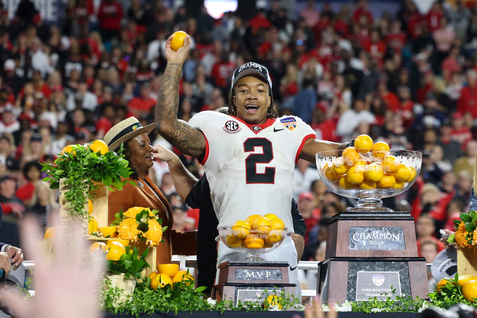 Georgia running back Kendall Milton (2) the MVP of the game celebrates by throwing oranges to teammates after Georgia’s 63-3 win against Florida State in the Orange Bowl at Hard Rock Stadium, Saturday, Dec. 30, 2023, in Miami Gardens, Florida. (Jason Getz / Jason.Getz@ajc.com)