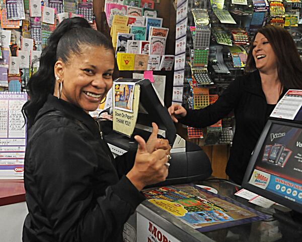 Debora Hill gives a thumbs up while buying her Mega Million tickets at Vinny’s Bar & Grille. STAFF PHOTO / MARSHALL GORBY