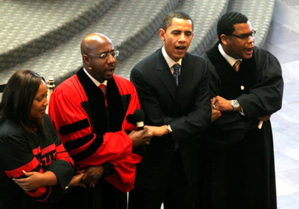 Associate minister Selina Smith, Rev. Raphael Warnock, Sen. Barack Obama and associate minister Shanan Jones hold hands and sing "We Shall Overcome" along with the rest of the people gathered at Ebenezer Baptist Church Sunday.