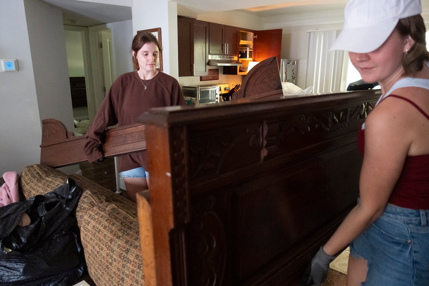 Lauren Bryant, left, helps her friend Hope Ferguson remove her bed while cleaning up Ferguson’s flooded apartment at the Peachtree Park Apartments in Atlanta on Saturday, Sept. 28, 2024.   Ben Gray for the Atlanta Journal-Constitution