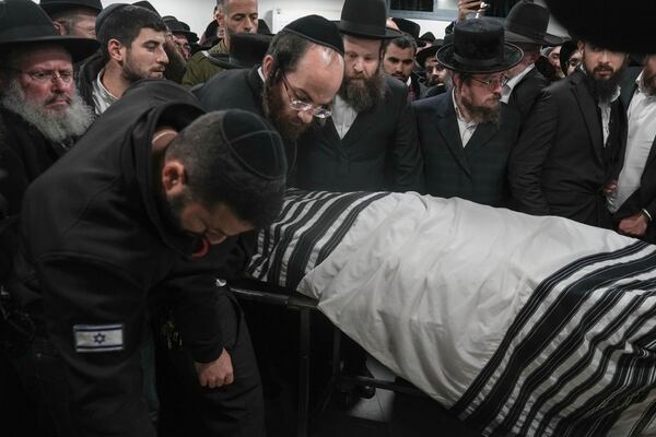 The body of Israeli-Moldovan rabbi Zvi Kogan is carried into a funeral home before his burial in Jerusalem, Monday Nov. 25, 2024. Kogan, 28, an ultra-Orthodox rabbi, was killed last week in Dubai where he ran a kosher grocery store. Israelis have flocked for commerce and tourism since the two countries forged diplomatic ties in the 2020 Abraham Accords.(AP Photo/Mahmoud Illean)