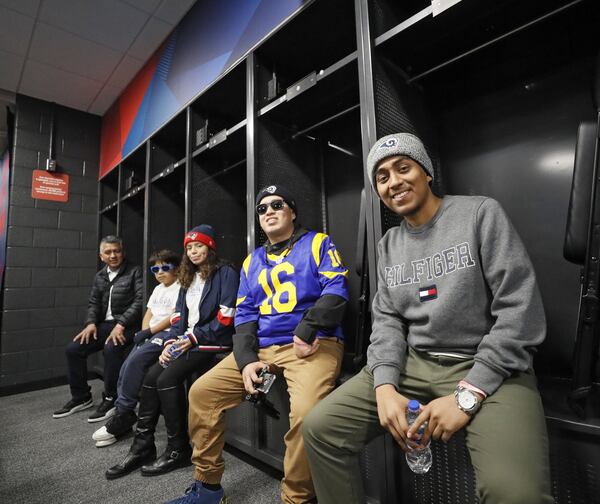 Eder Barrios (from left) and his children, German, Yeimi, Joshua, and Bryan sit in the Patriots locker room in Mercedes-Benz Stadium. Bryan, 19, has lymphoblastic lymphoma. His favorite is the Rams.. Bob Andres / bandres@ajc.com