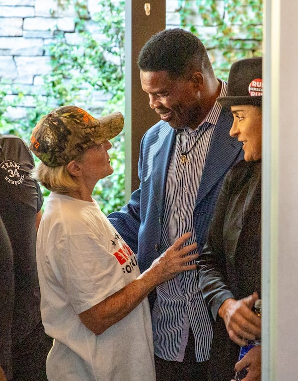 Before taking the stage at a campaign event in Gwinnett County, Herschel Walker talks to supporter Sharon Follmer. In is showdown with Democratic U.S. Sen. Raphael Warnock, Walker is depending on white Republicans, especially white evangelical voters who make up the GOP base — to put him in office. (Jenni Girtman for The Atlanta Journal-Constitution)