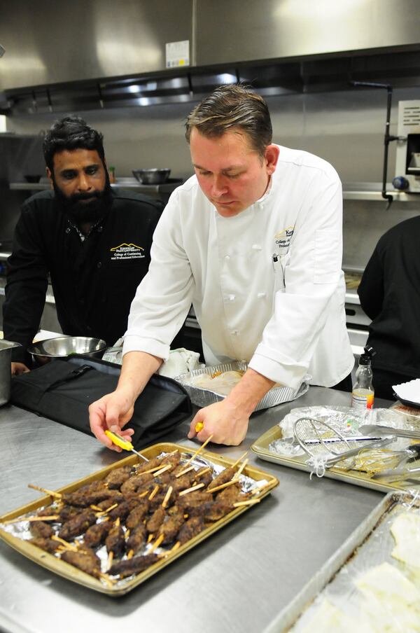 Chef Robert Gerstenecker is the culinary instructor for KSU’s Culinary Apprenticeship Certificate Program. In the university’s catering kitchen, he tests the temperature of Venkata Nekkanti’s kabab Lahore. CONTRIBUTED BY TODD HULL