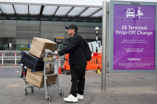 A traveller arrives with his lugage at Terminal 4 as Britain's Heathrow Airport has closed for the full day Friday after an electrical substation fire knocked out its power, disrupting flights for hundreds of thousands of passengers at one of Europe's biggest travel hubs in London, Friday, March 21, 2025.(AP Photo/Kin Cheung)