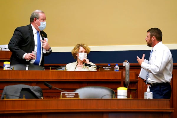 Rep. Larry Bucshon, R-Ind., right, speaks to Reps. Susan Brooks, R-Ind., and Markwayne Mullin. R-Okla., during a House Energy and Commerce Subcommittee on Health hearing on protecting scientific integrity in response to the coronavirus outbreak on Thursday, May 14, 2020, on Capitol Hill in Washington. (Greg Nash/Pool via AP)