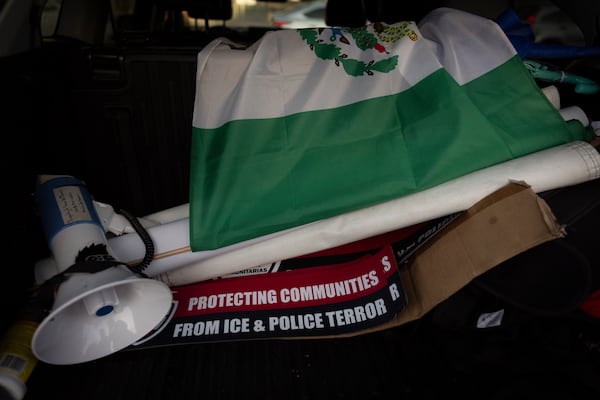 A megaphone, a Mexican flag, and signs sit in the trunk of Ron Gochez's car after he finished searching for ICE activity in a neighborhood in Los Angeles on Thursday, Feb. 27, 2025. (AP Photo/Jae C. Hong)