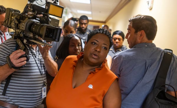 Ché Alexander, clerk of Fulton’s superior and magistrate courts, is surrounded by media while holding indictment papers during the grand jury hearing for former President Trump at the Fulton County Courthouse on Aug. 14, 2023 in Atlanta. (Michael Blackshire/Michael.blackshire@ajc.com)