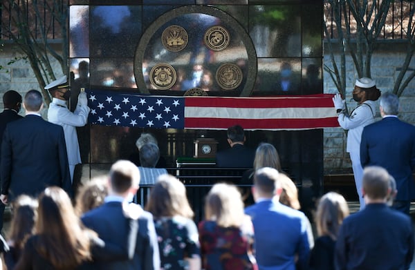 A Navy team fold and prepare to present the U.S. flag to family members of Howard R. Orr of Johns Creek, a Navy veteran who served in the Korean War and was memorialized at Georgia National Cemetery in Canton earlier this month. A team of Marine veterans based in nearby Woodstock helped provide services, including three volleys of shots as a final salute. (Hyosub Shin / Hyosub.Shin@ajc.com)