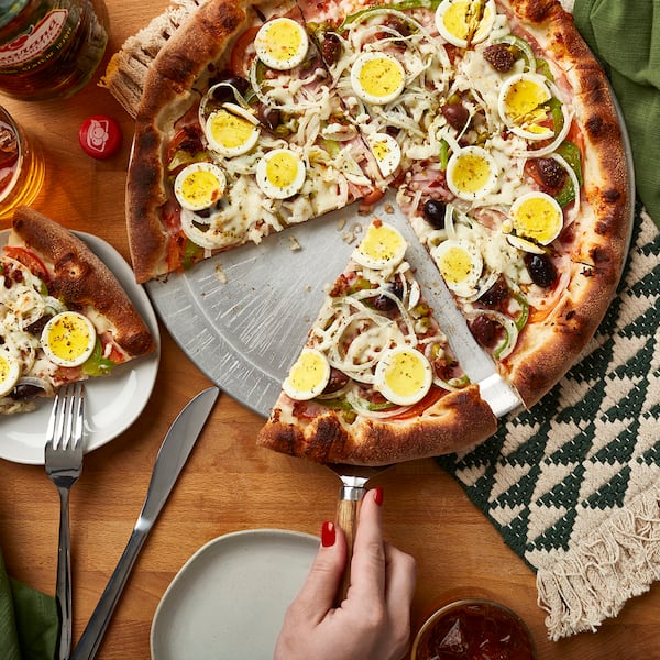 Toppings on the Portuguesa pizza from Pizza Brasiliana in the Southern Feed Store food hall in East Atlanta include hard-boiled eggs and black olives. Courtesy of Brasiliana Pizza 