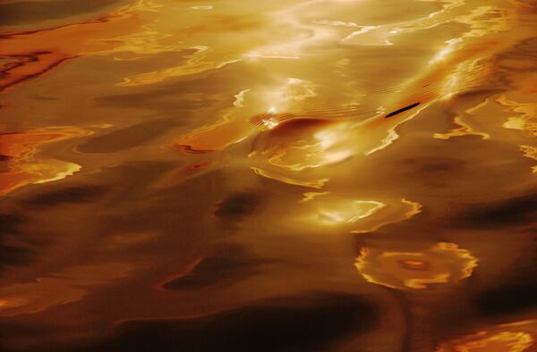 Marilyn Suriani captures a spectacular moment in "Burnt Orange" the fiery reflection of sunset on water in a photograph that is abstract and painterly.

Photo: Courtesy the artist
