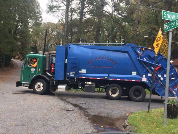 A sanitation truck driver picks up recycling materials in Atlanta. Photo by Bill Torpy